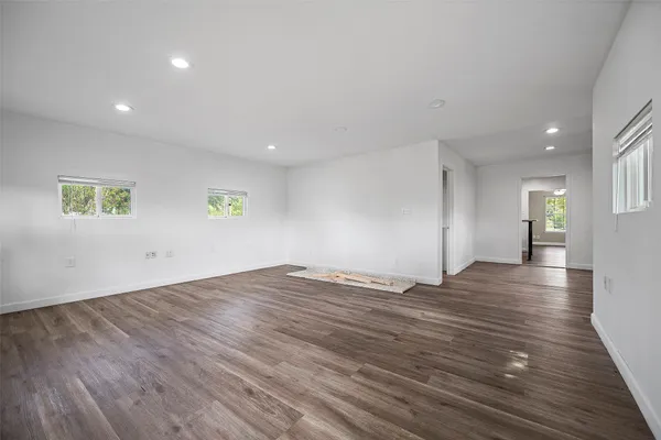 a view of empty room with wooden floor