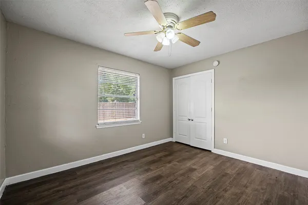a view of a big room with wooden floor and windows