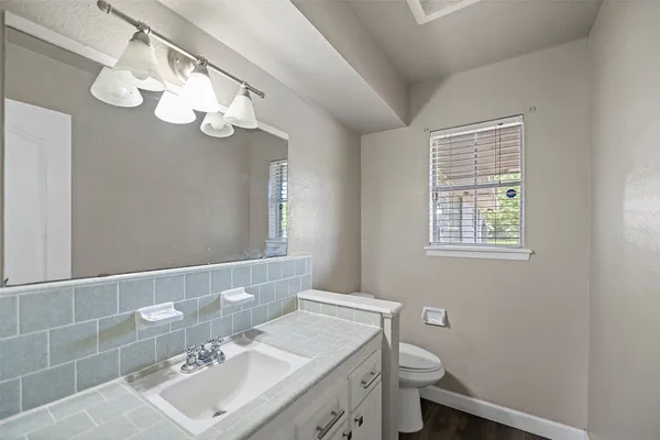 a bathroom with a sink a toilet and a mirror