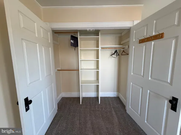 an empty room with wooden floor a ceiling fan and closet