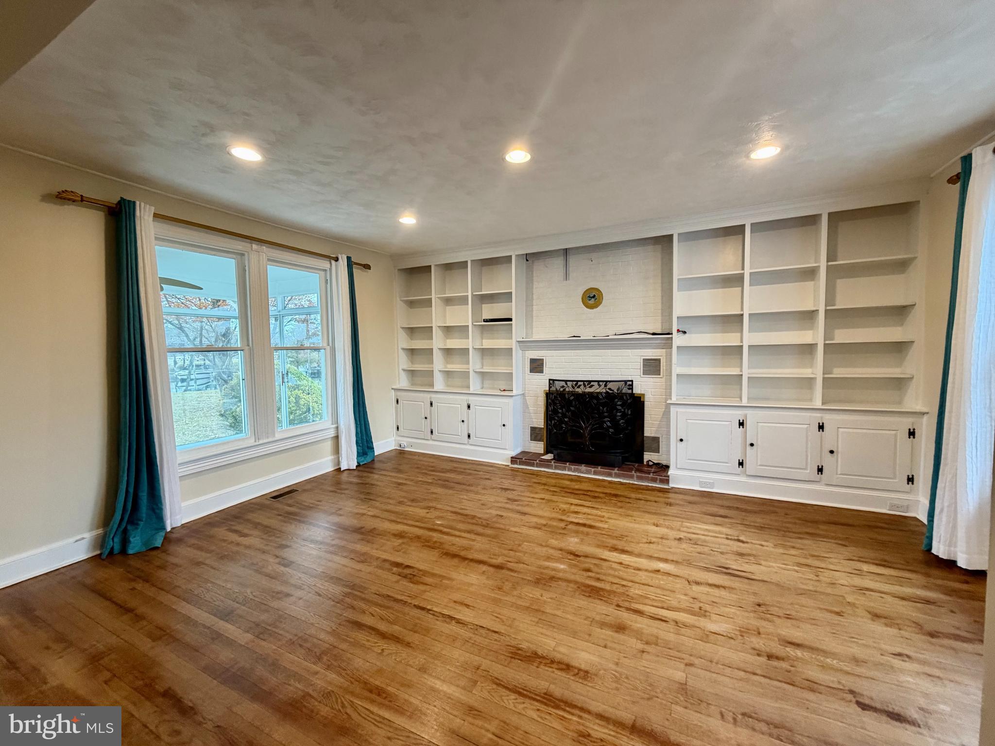 48600 Deep Cove Lane Ridge, MD 20680 - Photo 4 of 46 an empty room with a fireplace and window
