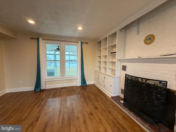 a view of an empty room with a fireplace and a window