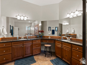 514 North Olympic Way Midway, UT 84049 - Photo 11 of 30 Expansive vanity area featuring dual integrated sinks, dark stone countertops, and extensive wood-finish cabinetry