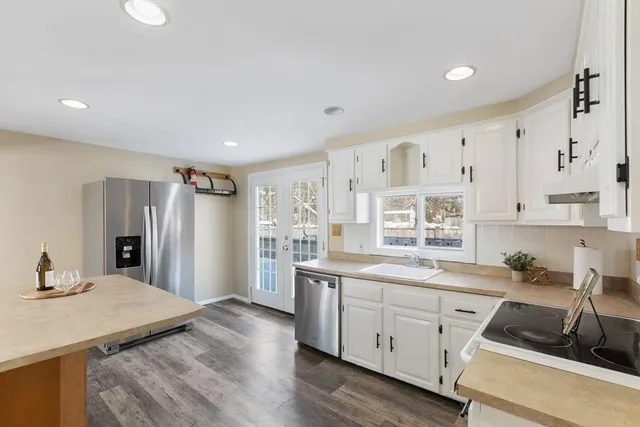a kitchen with stainless steel appliances kitchen island granite countertop a sink and cabinets