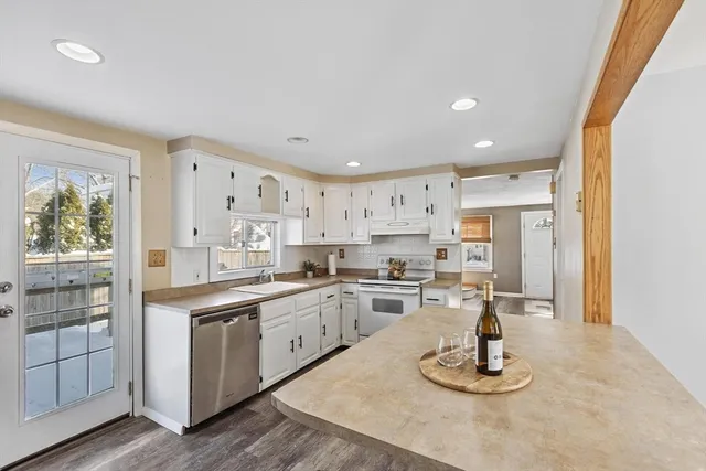 a kitchen with stainless steel appliances kitchen island granite countertop a sink and cabinets