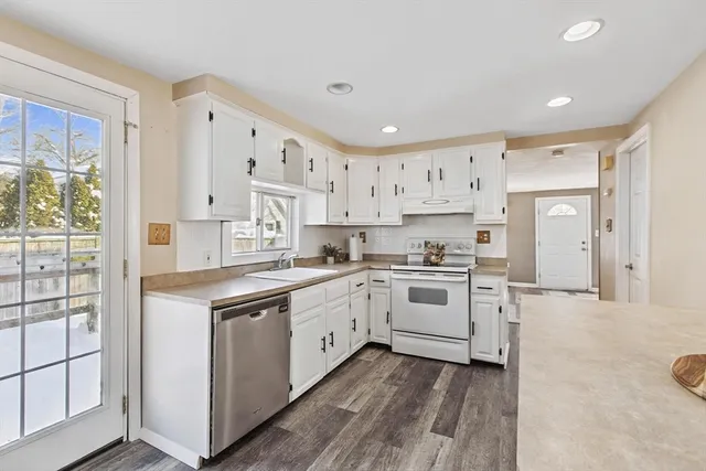 a kitchen with stainless steel appliances granite countertop a sink and cabinets with wooden floor