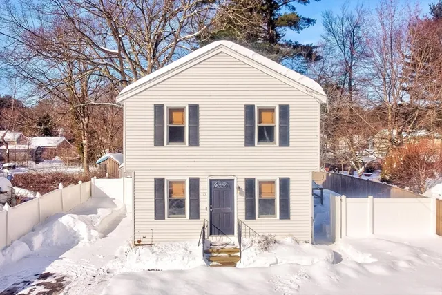 a front view of a house with a yard covered in snow