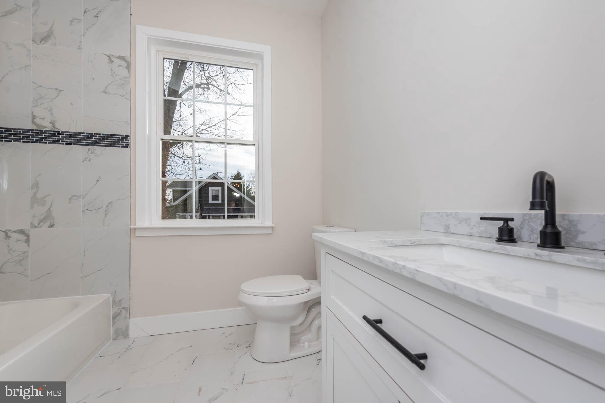 9624 Harford Road Parkville, MD 21234 - Photo 25 of 39 a bathroom with a granite countertop sink a toilet and bathtub