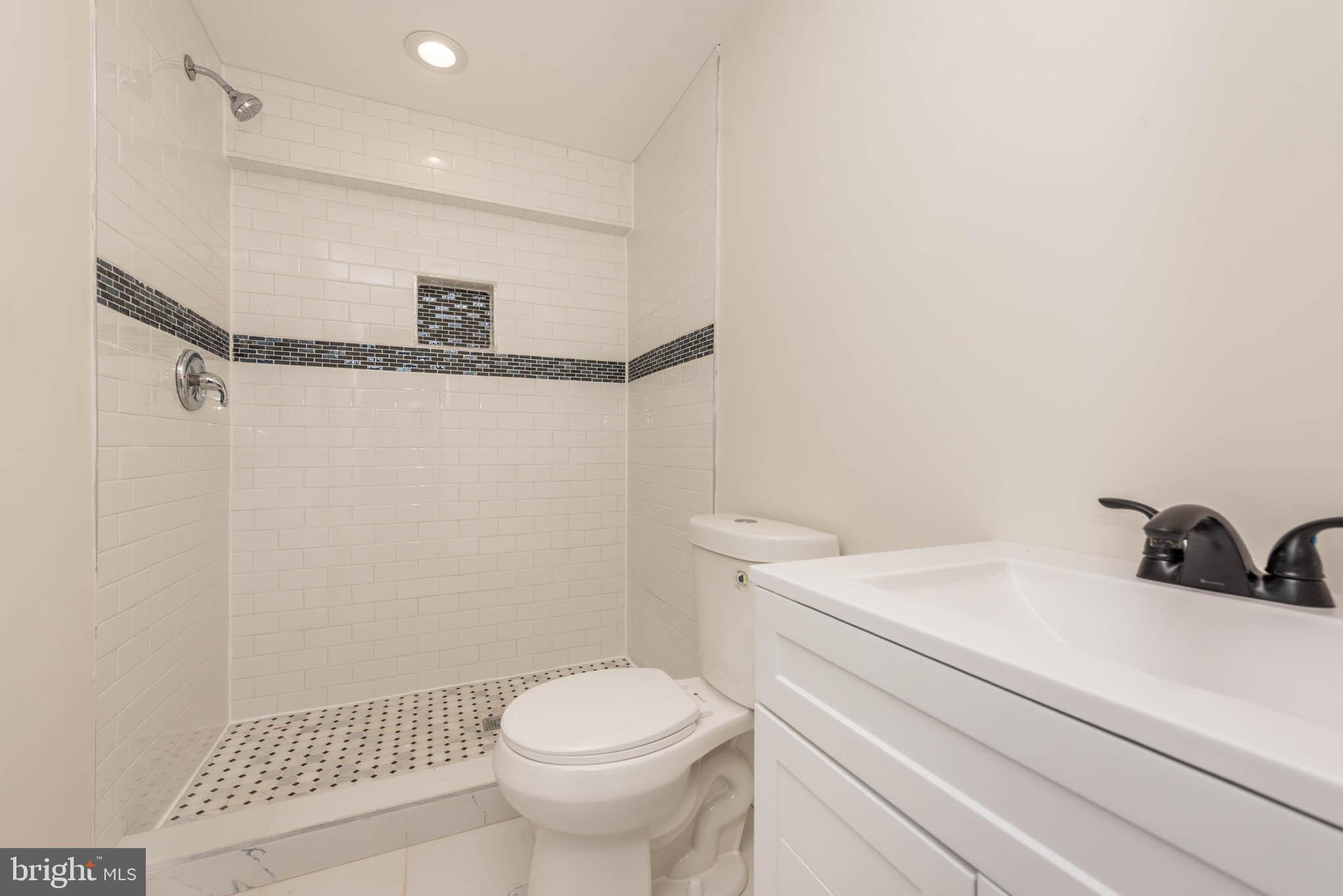 9624 Harford Road Parkville, MD 21234 - Photo 33 of 39 a bathroom with a sink a toilet and a shower