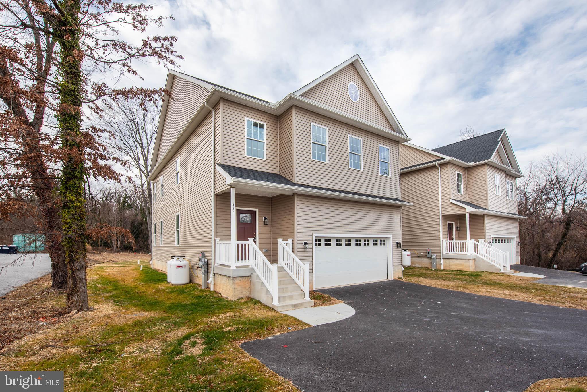 9624 Harford Road Parkville, MD 21234 - Photo 37 of 39 a view of a white house with a large tree and a yard