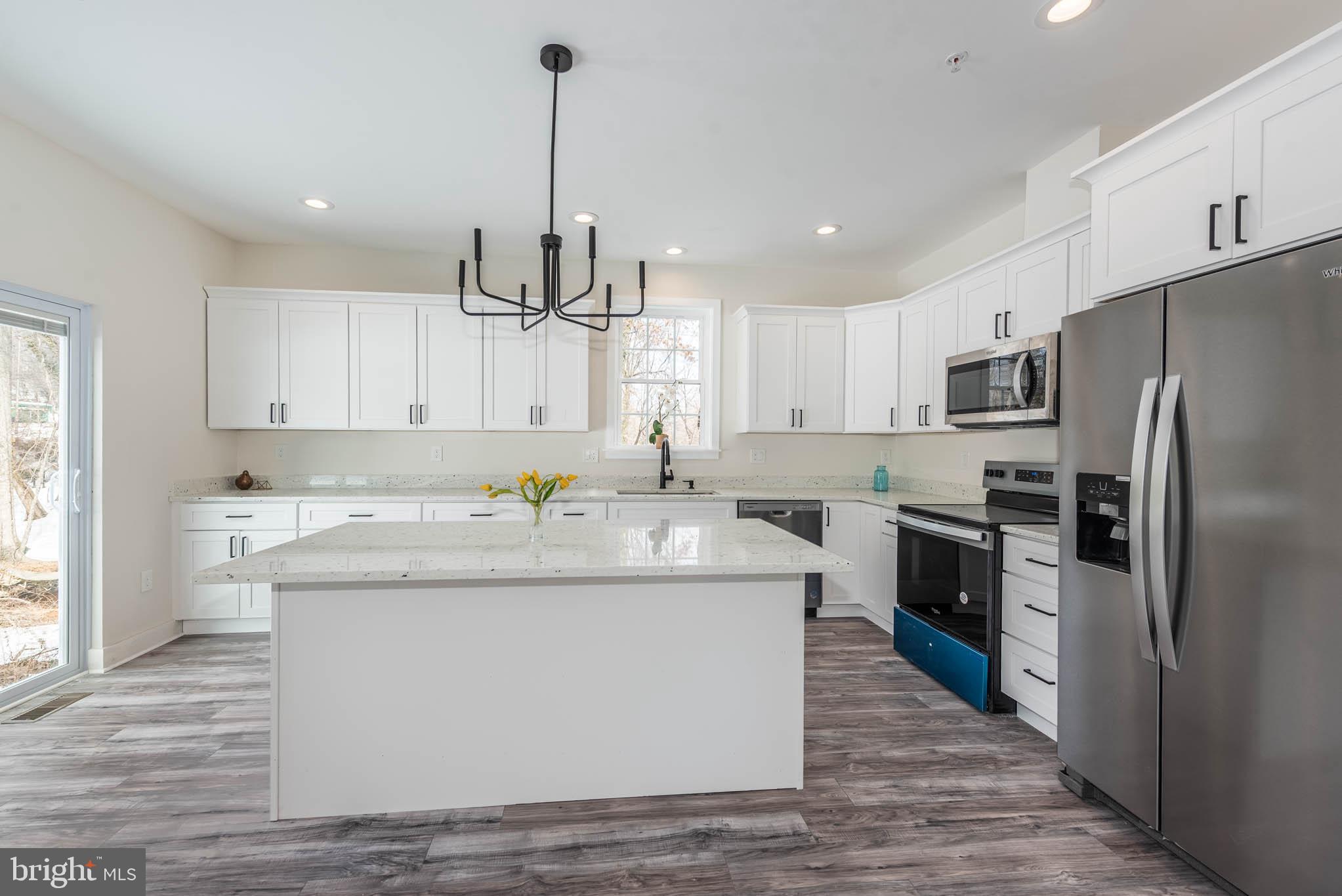 9624 Harford Road Parkville, MD 21234 - Photo 8 of 39 a kitchen with kitchen island a sink stainless steel appliances and cabinets