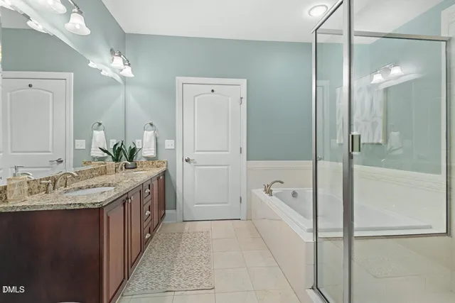 a bathroom with a granite countertop sink a large mirror and a bathtub