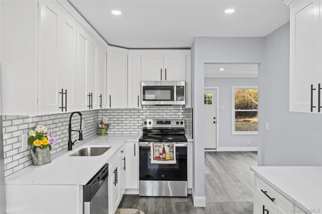 a kitchen with stainless steel appliances a sink a stove and a refrigerator
