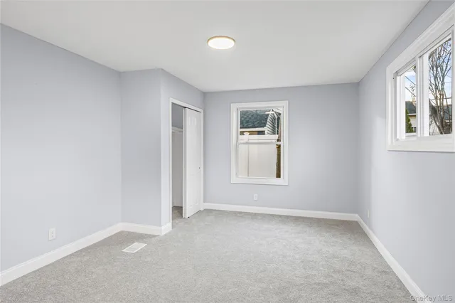 an empty room with windows and closet