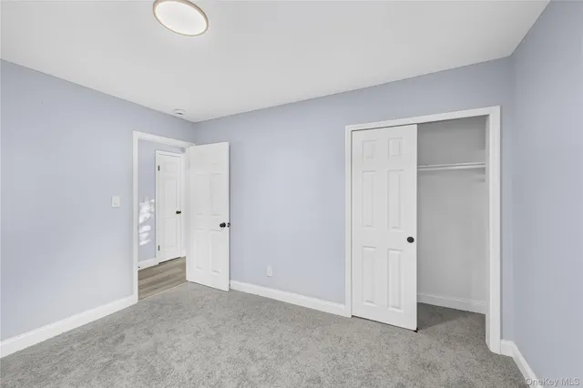 a view of a hallway with wooden floor and closet area