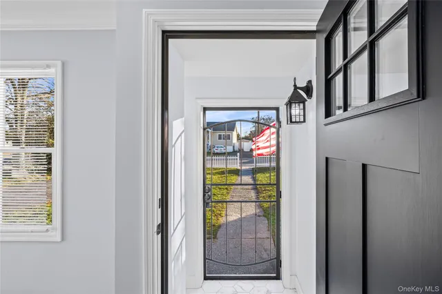a view of empty room with wooden floor and kitchen view