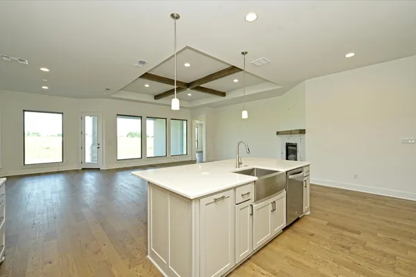 wooden floor with white cabinets and chandelier