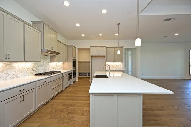 a large kitchen with kitchen island a sink stainless steel appliances and cabinets