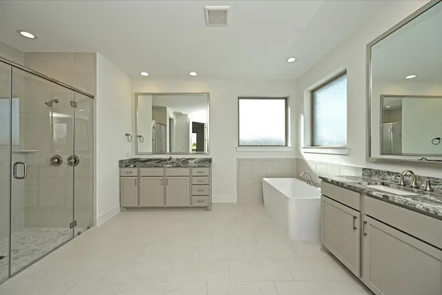 a bathroom with a double vanity sink a toilet a mirror and shower