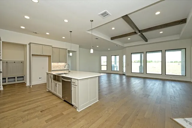 a large kitchen with stainless steel appliances granite countertop a stove and a large window