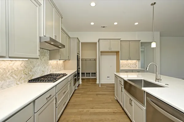 a kitchen with stainless steel appliances a sink stove and cabinets