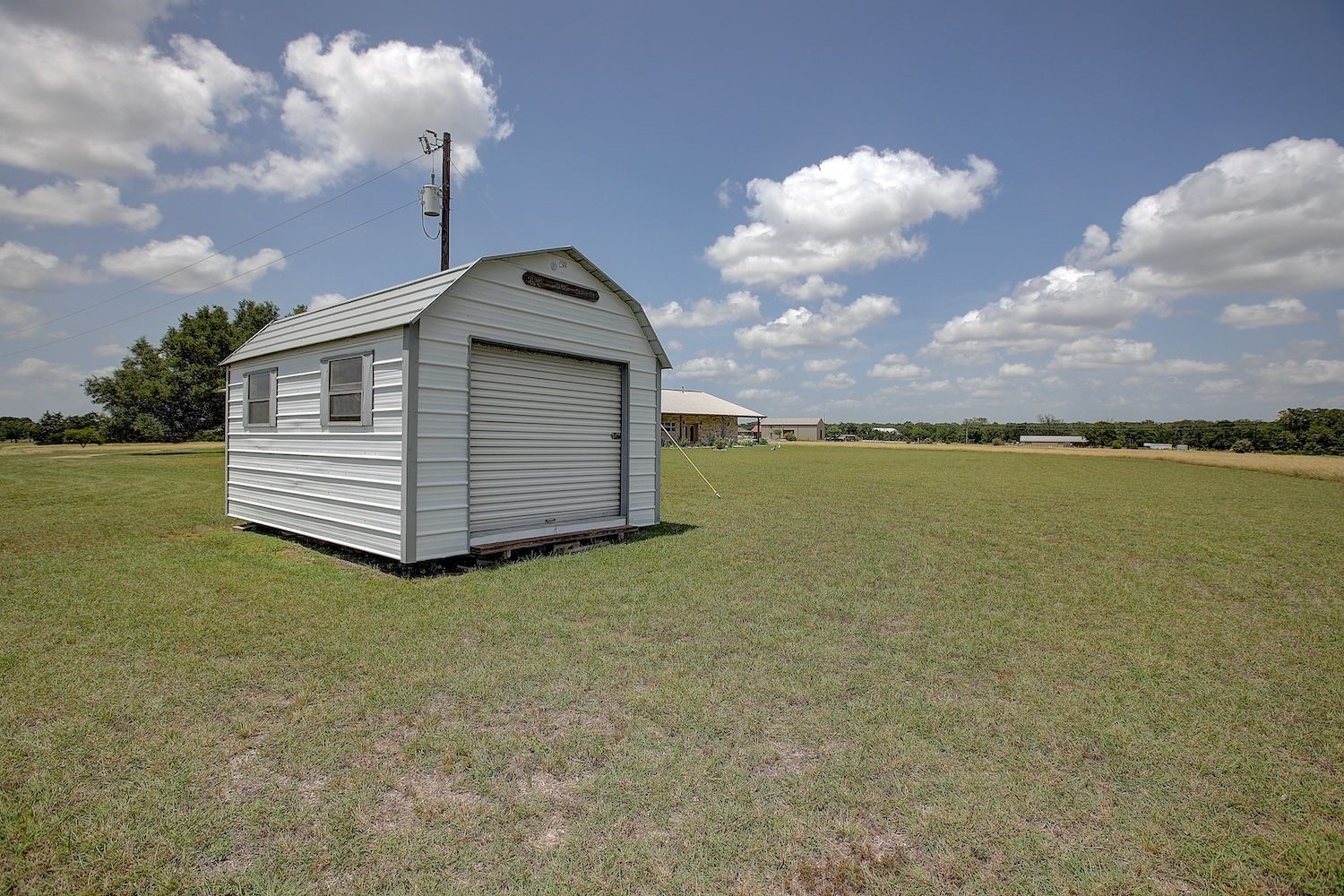 9414 Laird Road Round Top, TX 78954 - Photo 8 of 50 Storage shed next to the metal building with electrical pole for ease of an RV hookup