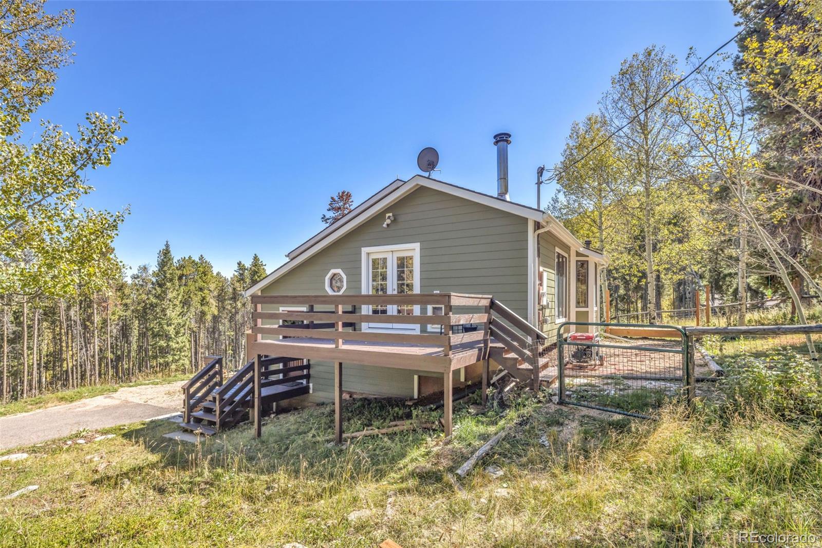 32252 Steven Way Conifer, CO 80433 - Photo 12 of 47 a backyard of a house with table and chairs