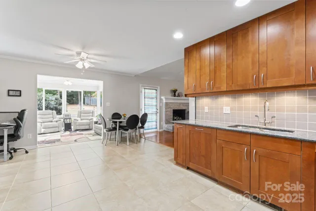 a kitchen with stainless steel appliances granite countertop a sink a stove cabinets dining table and chairs