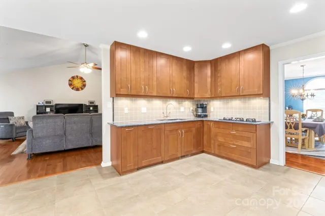 a kitchen with granite countertop a refrigerator and a stove top oven