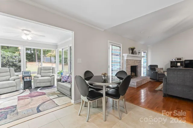 a living room with furniture a fireplace and a large window