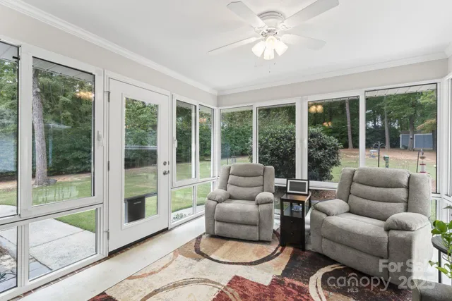 a living room with furniture and a floor to ceiling window