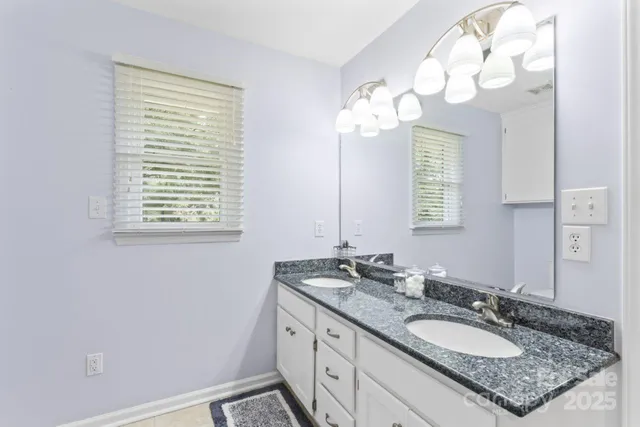 a bathroom with a granite countertop sink a mirror and a window
