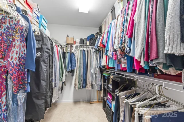 a view of walk in closet with clothes
