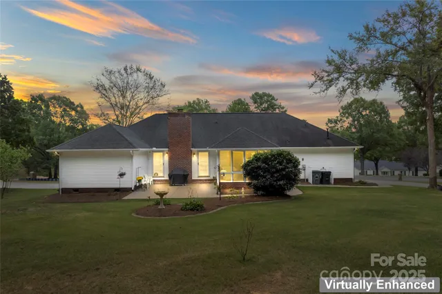 a front view of a house with a garden and trees