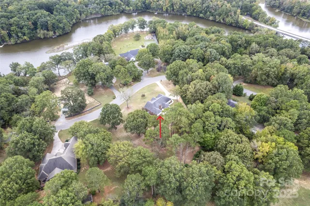 an aerial view of a house with a yard and lake view
