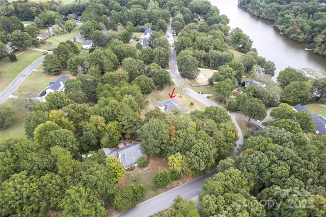 an aerial view of residential houses with outdoor space and trees all around