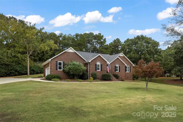 a front view of a house with a yard and trees
