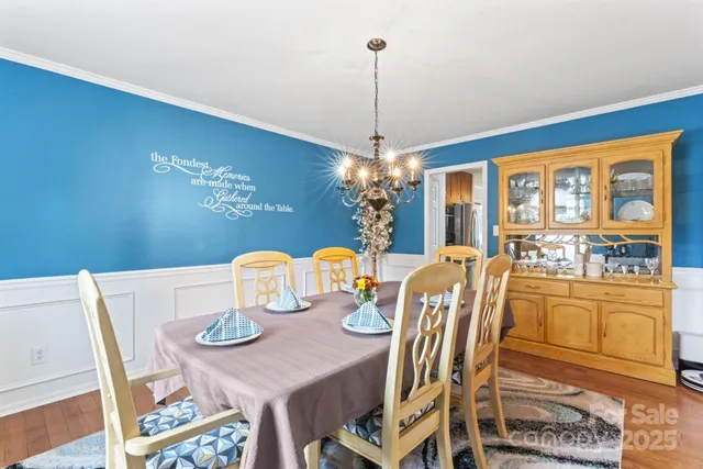 a view of a dining room with furniture a chandelier and wooden floor