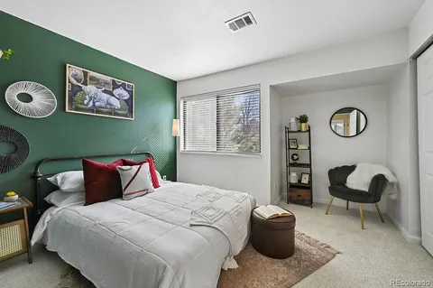 a bedroom with a bed and painting on the wall