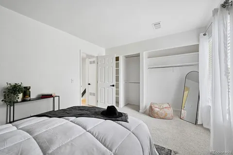 a bedroom with a bed and a potted plant