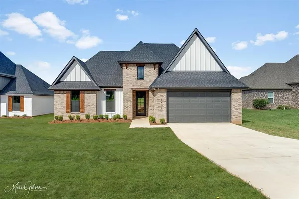 a front view of a house with a garden and yard
