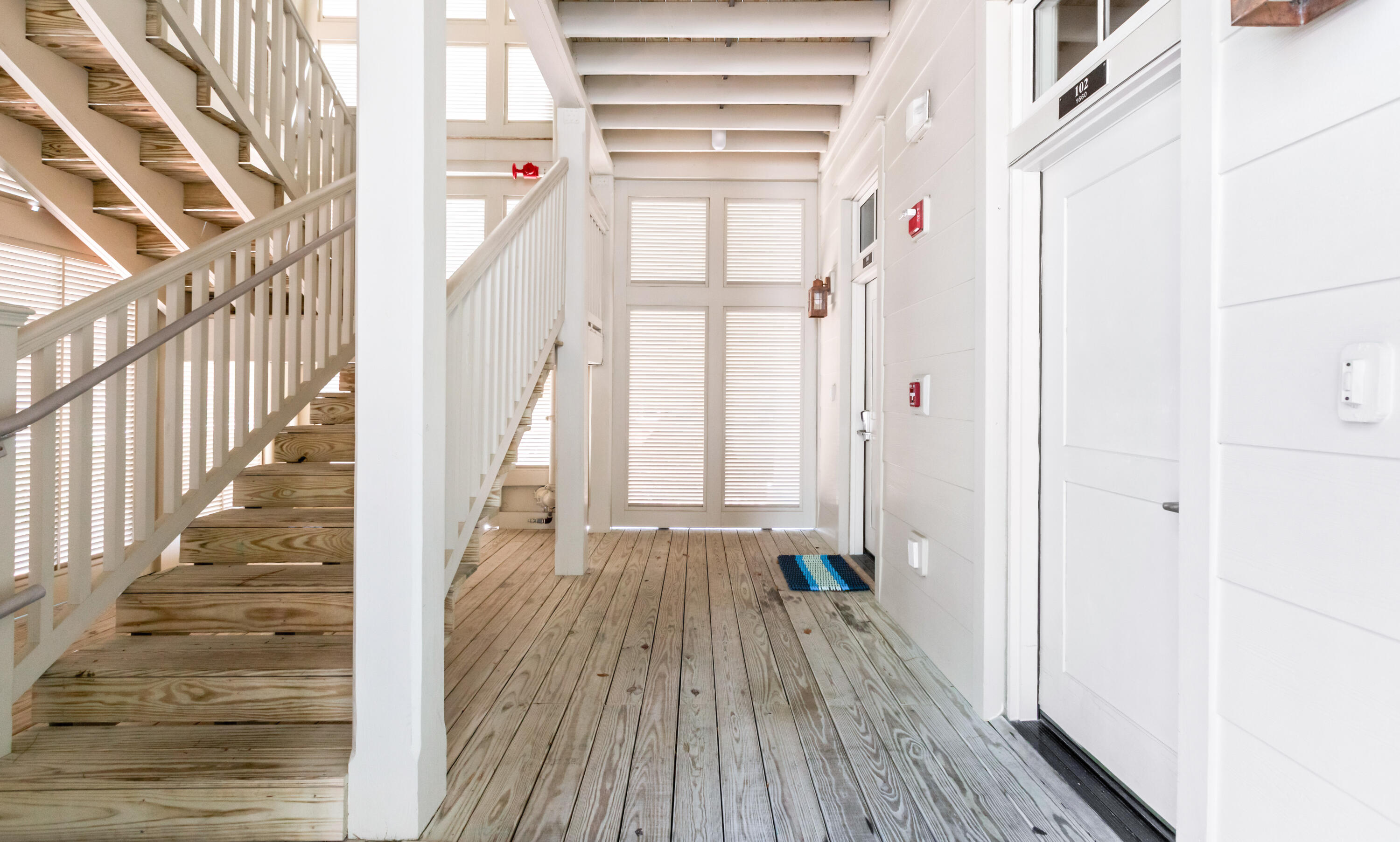 1660 East County Highway 30A, Unit 101 Santa Rosa Beach, FL 32459 - Photo 56 of 67 a view of an entryway with wooden floor and staircase