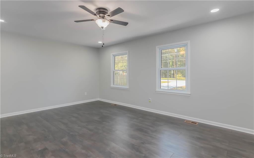 3206 Dillon Road Jamestown, NC 27282 - Photo 7 of 30 Newly painted living room with ceiling fan and windows facing the front of the house.