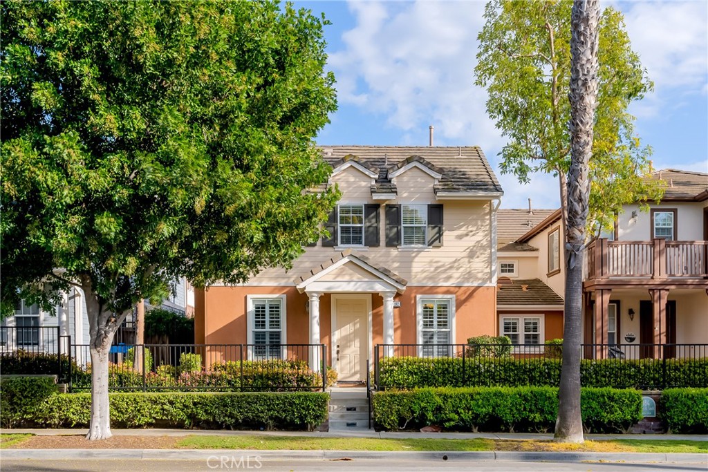 a front view of a residential houses with yard and tree