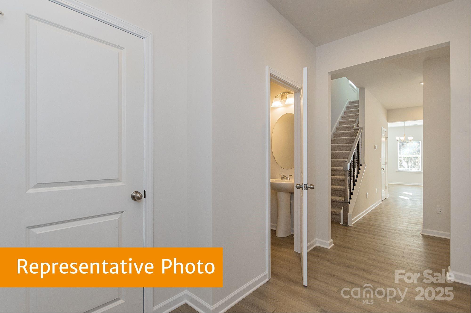6037 Jasmine Br Road Charlotte, NC 28216 - Photo 19 of 33 a view of hallway with wooden floor and stairs