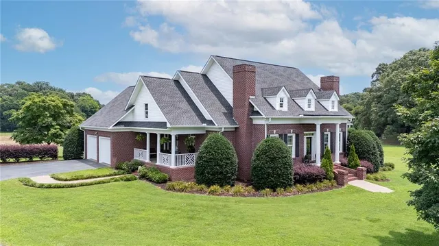 a front view of a house with a yard and potted plants