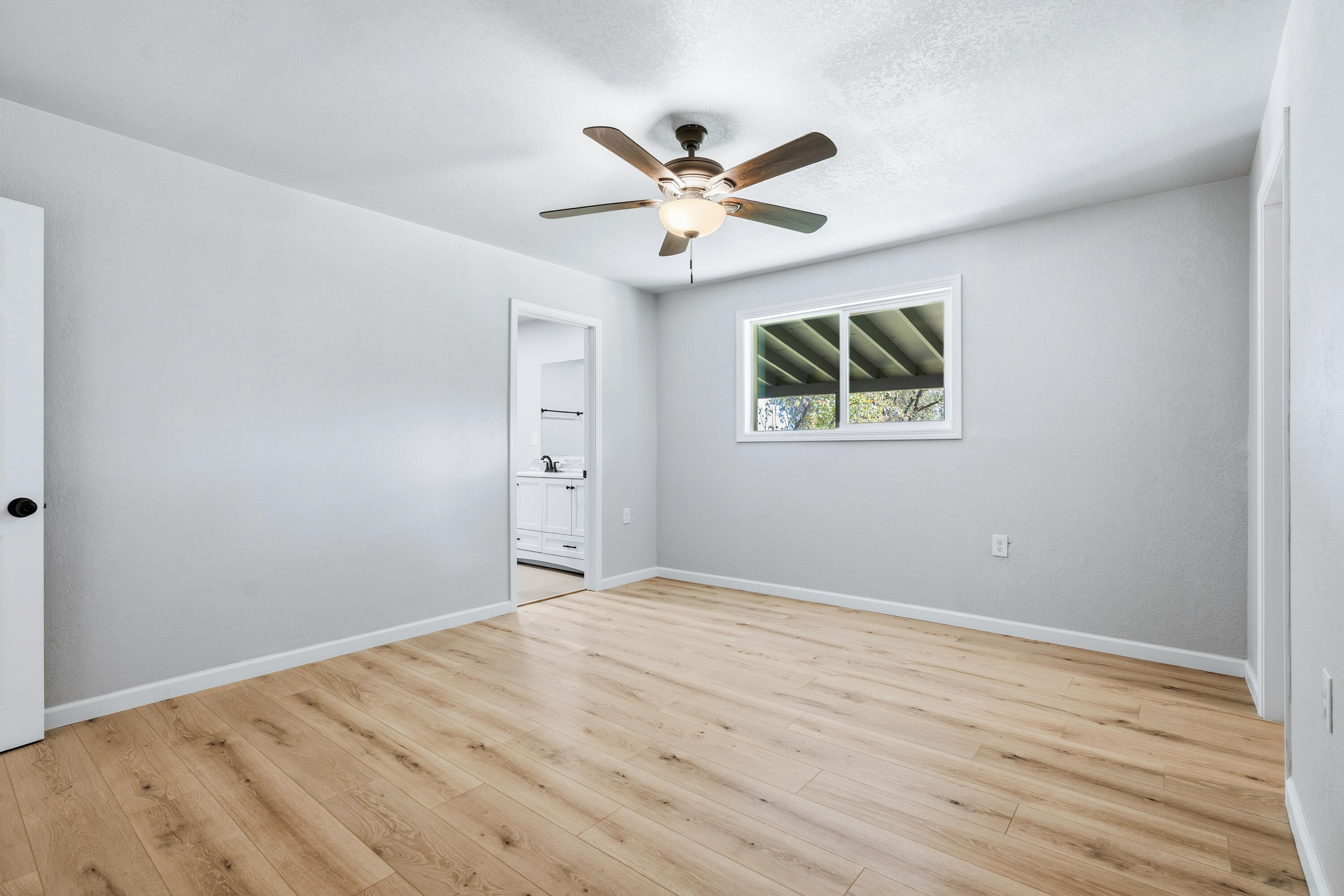 6673 Mountain View Drive Anderson, CA 96007 - Photo 21 of 42 an empty room with wooden floor ceiling fan and window