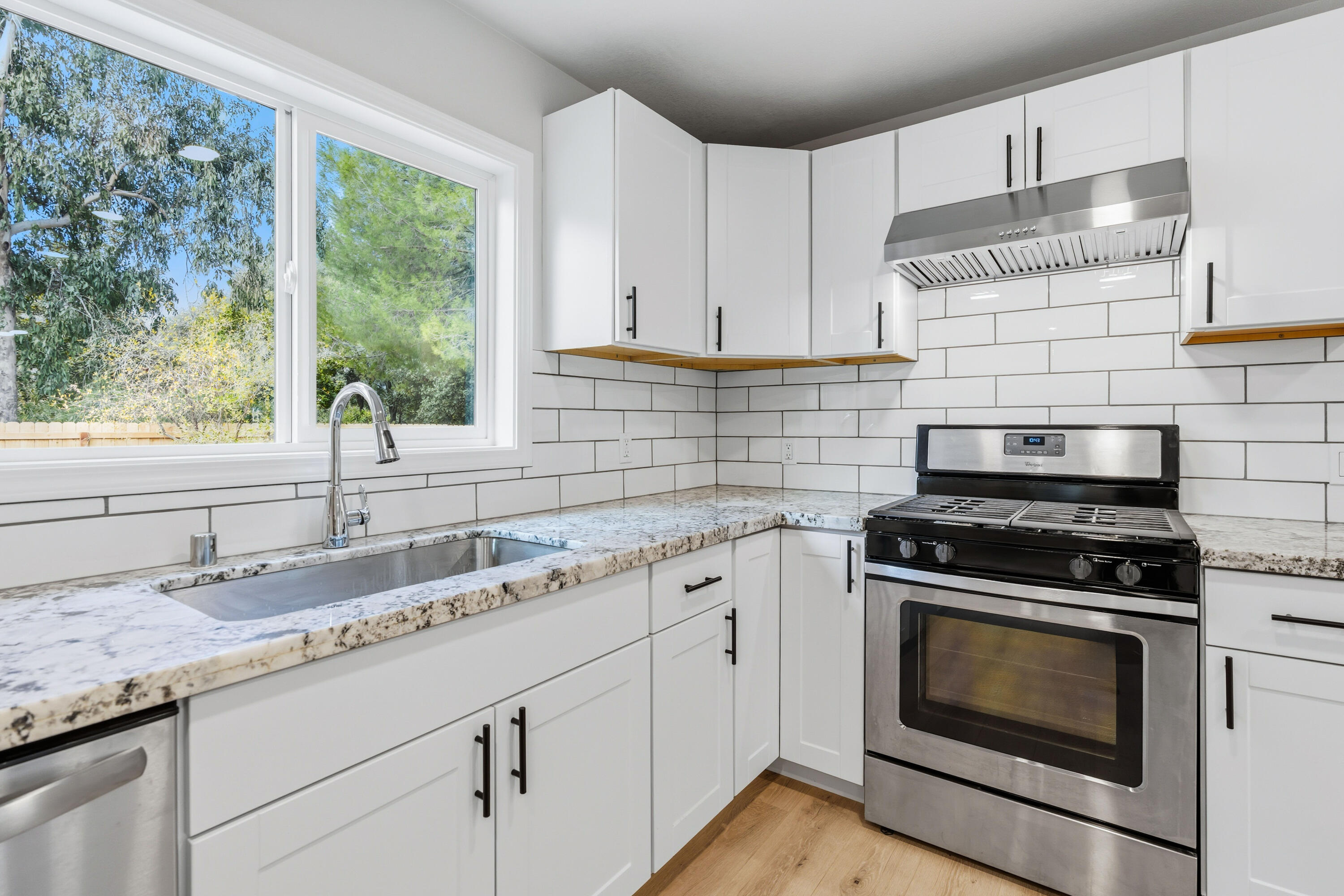 6673 Mountain View Drive Anderson, CA 96007 - Photo 25 of 42 a kitchen with granite countertop white cabinets and a stove top oven