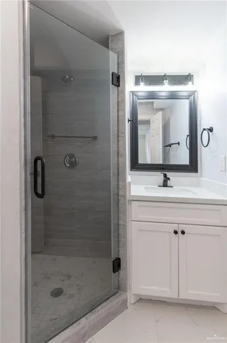 a bathroom with a shower sink and mirror
