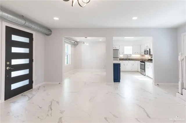 a view of a kitchen with kitchen island wooden floor and living room